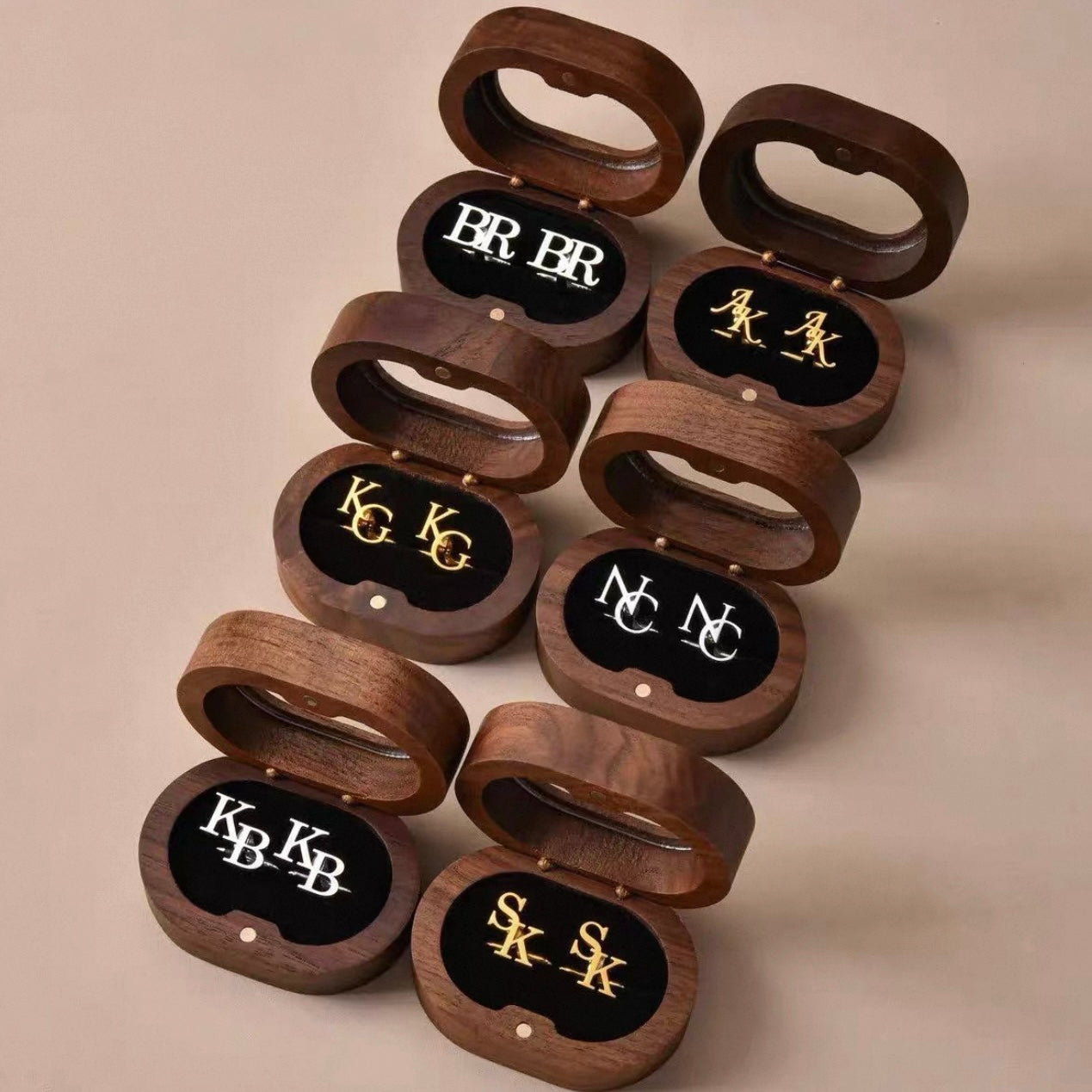 Set of wooden bottle openers with engraved initials on a beige background
