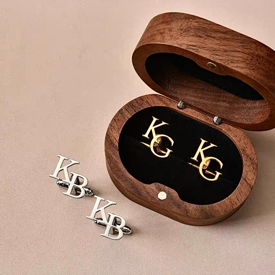 Wooden jewelry box with gold and silver 'KG' and 'KB' initials on a beige background