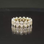 A dynamic video of the full oval diamond eternity band rotating on a dark reflective surface, capturing the brilliant fire of the VS clarity stones.