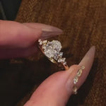 Three variations of the Shooting Star Spark ring (Oval, Round, and Cushion cuts) held in a hand to show the celestial design options.