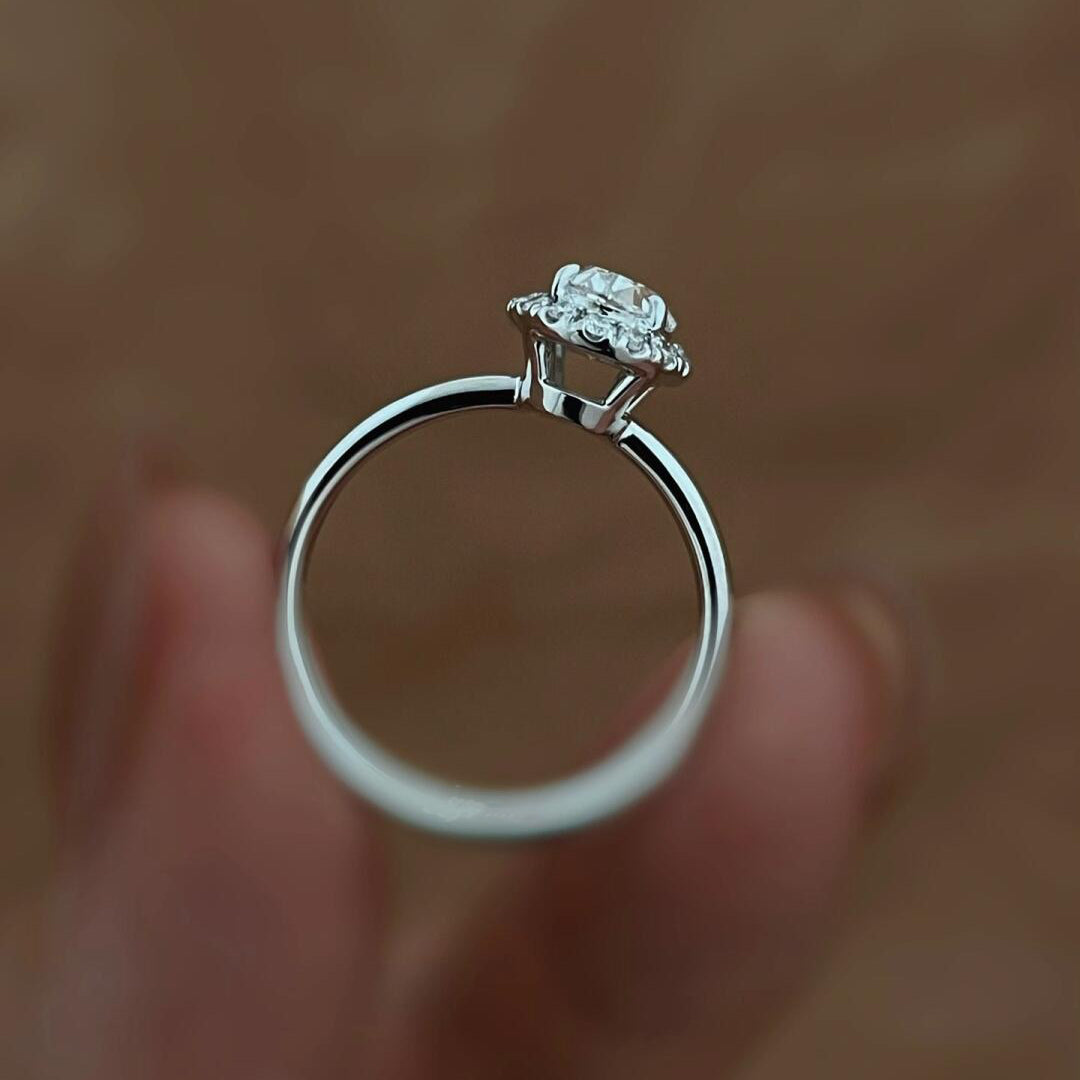 A woman's hand modeling the 2.06 ct oval halo diamond ring, highlighting its elegant proportions and brilliant sparkle.