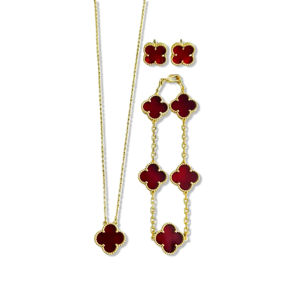 An elegant 18K gold plated jewelry set featuring a black four-leaf clover necklace, matching bracelet, and stud earrings laid on a white background.