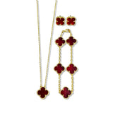An elegant 18K gold plated jewelry set featuring a black four-leaf clover necklace, matching bracelet, and stud earrings laid on a white background.