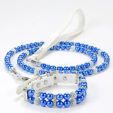 A royal blue simulated pearl pet collar resting on its corresponding blue beaded leash.