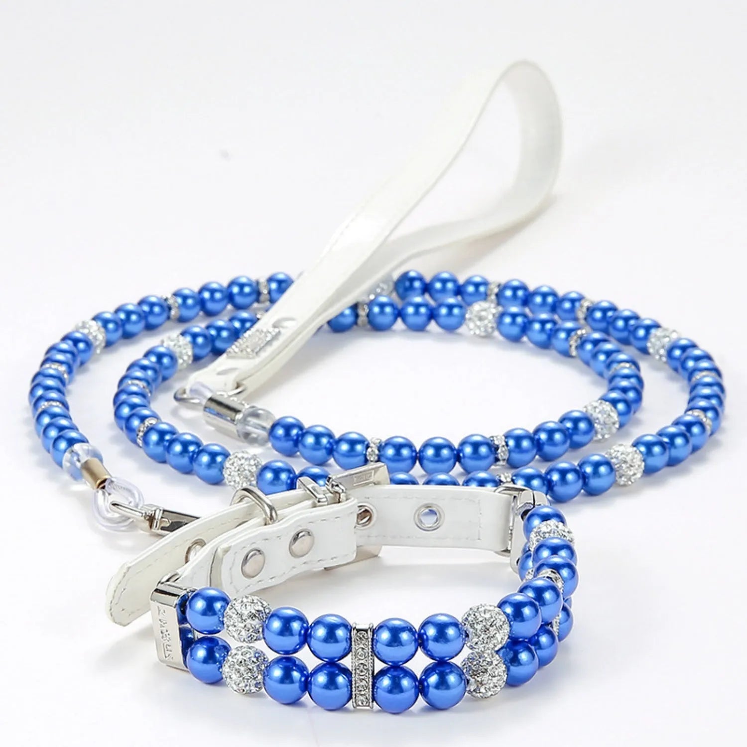 A royal blue simulated pearl pet collar resting on its corresponding blue beaded leash.