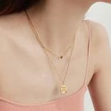 Close-up of a woman wearing the dainty 18K gold plated scattered hearts station necklace on her collarbone.