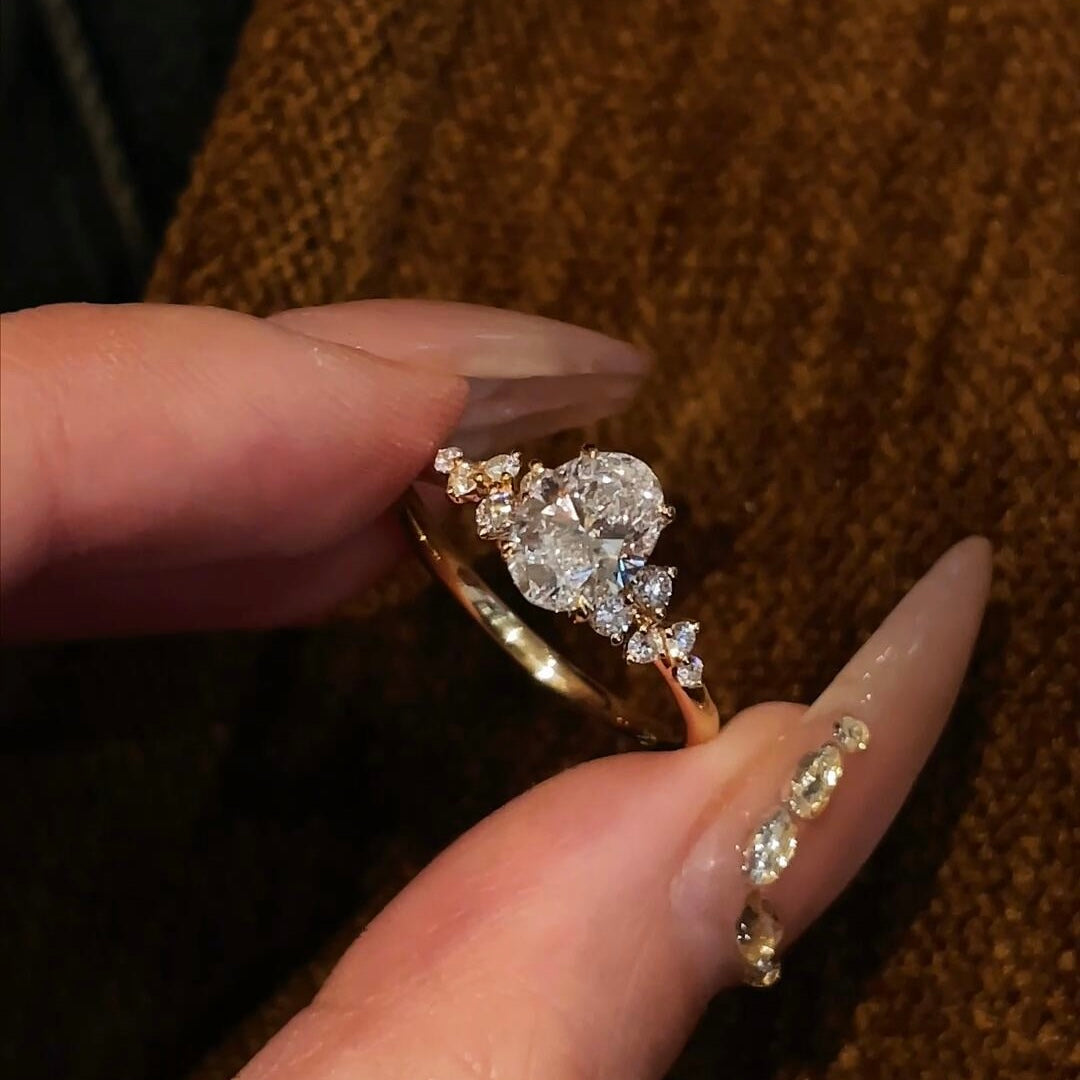 Close-up of the Shooting Star Spark lab-grown diamond ring featuring a brilliant oval center stone and a curved diamond trail on a gold band.