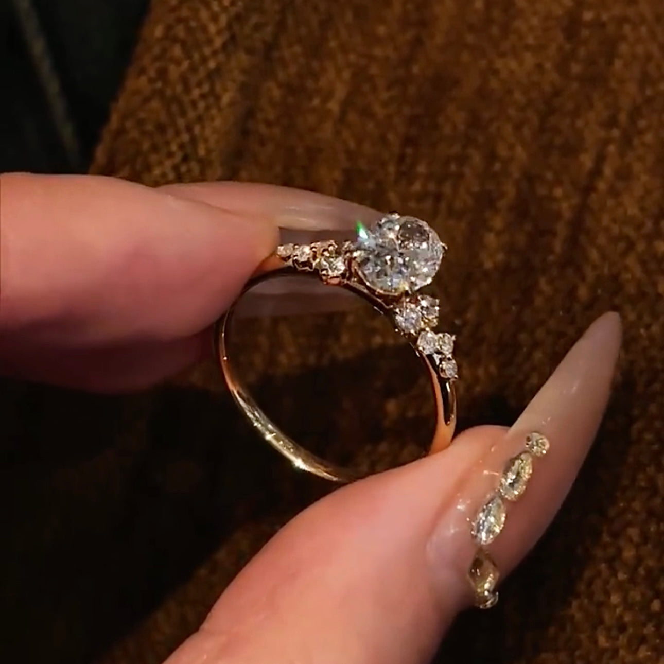 Close-up of the Shooting Star Spark lab-grown diamond ring featuring a brilliant oval center stone and a curved diamond trail on a gold band.