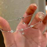 A hand holding a 925 sterling silver clover bracelet, demonstrating the innovative adjustable sliding bolo clasp for a perfect fit.