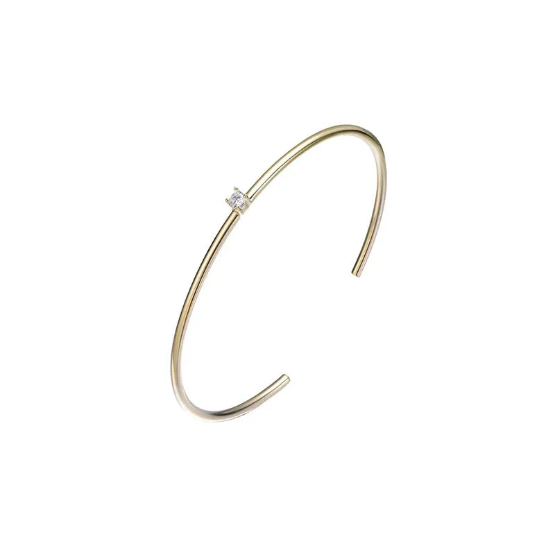 Isolated studio product photograph of an 18K gold-plated Solitaire Open Cuff bangle on a pure white background.