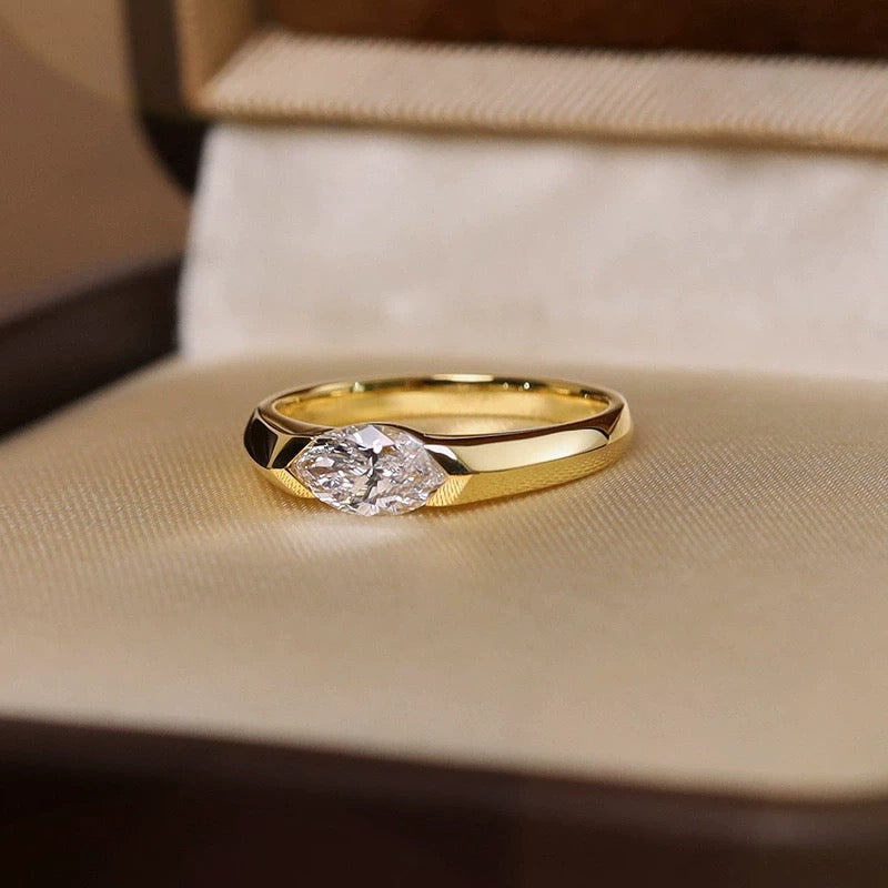 A marquise-cut lab diamond ring in 18K yellow gold, nestled in a premium velvet-lined ring box.