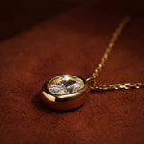 Detailed angled shot of the "bathtub" style thick gold bezel encasing the brilliant oval lab-grown diamond.