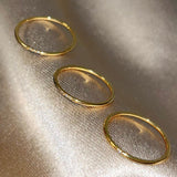 Close-up detail of the Essential Stacking Ring Trio, highlighting the intricate craftsmanship of the different gold bands.