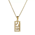 A gold rectangular tarot card pendant labeled THE MOON, featuring a white enamel background, a gold crescent moon, clouds, and star motifs accented with clear cubic zirconia.