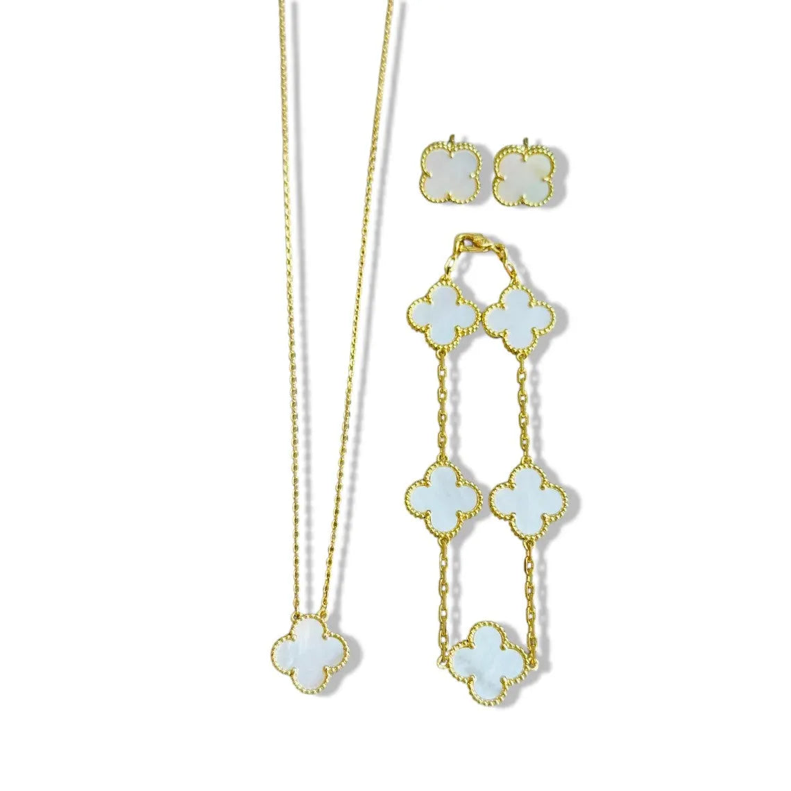 An elegant 18K gold plated jewelry set featuring a black four-leaf clover necklace, matching bracelet, and stud earrings laid on a white background.