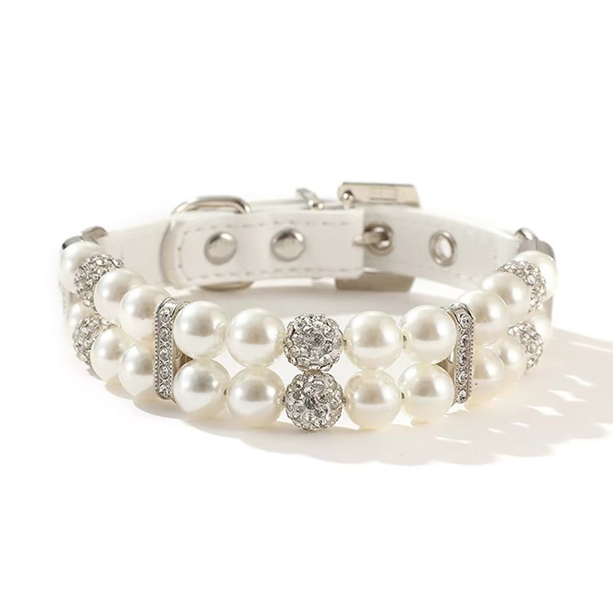 Close-up macro view of a white simulated pearl pet collar featuring sparkling round rhinestone spacer beads and a white PU leather adjustable buckle strap.