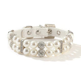 Close-up macro view of a white simulated pearl pet collar featuring sparkling round rhinestone spacer beads and a white PU leather adjustable buckle strap.