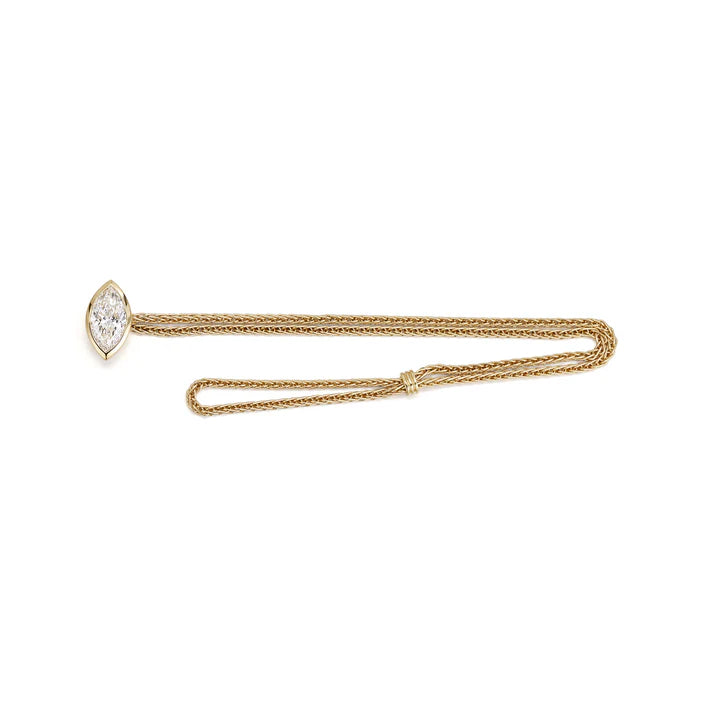 Flat lay of the 18K gold woven chain bracelet showcasing the unique loop closure and brilliant bezel-claw set marquise diamond.