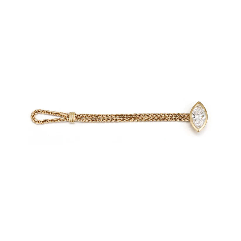Flat lay of the 18K gold woven chain ring demonstrating the innovative flexible loop closure and brilliant bezel-claw set marquise diamond.